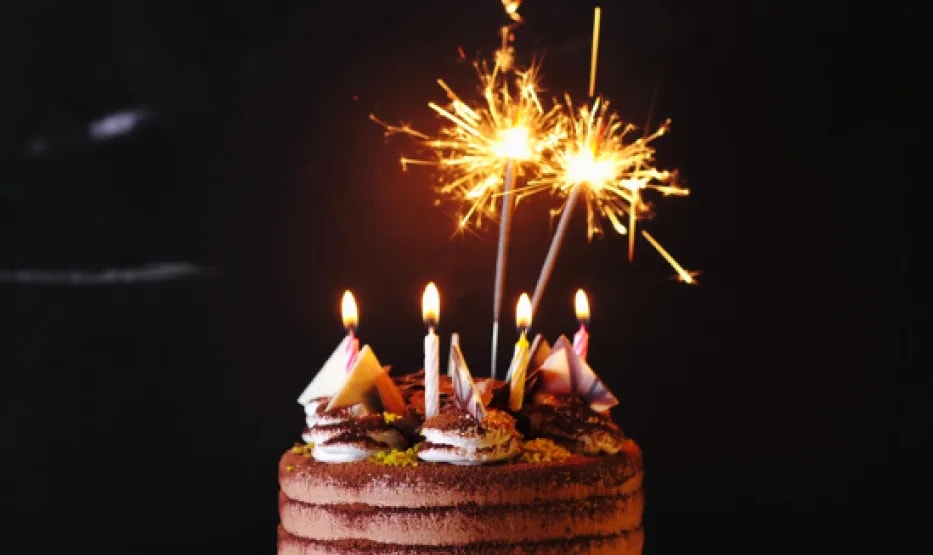 Tarta de cumpleaños de chocolate con velas y una bengala encendida